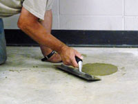 Repairing the cored holes in the concrete slab floor with fresh concrete and cleaning up the Pikeville home.