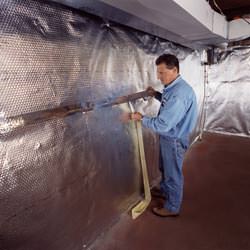 Installation of a radiant heat and vapor barrier on a basement wall in Greenup